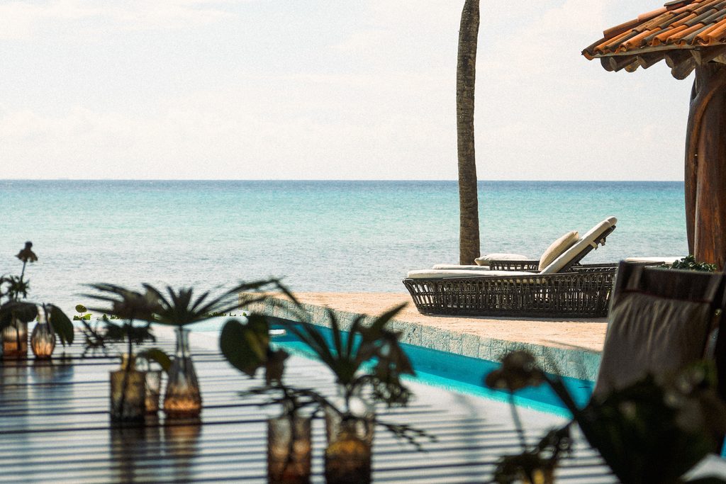 Alberca y Mar Caribe enmarcados por la palapa de Casa Corazón, Playa del Carmen