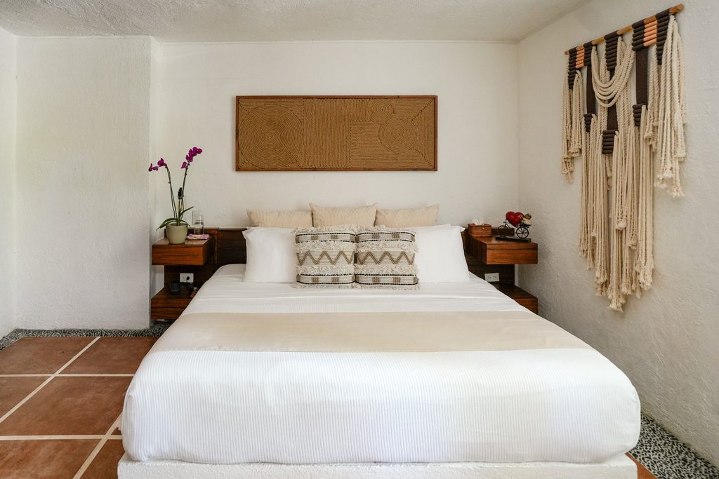 Recámara con tapiz de macramé y piso de barro en Casa Corazón, villa de lujo en Playacar