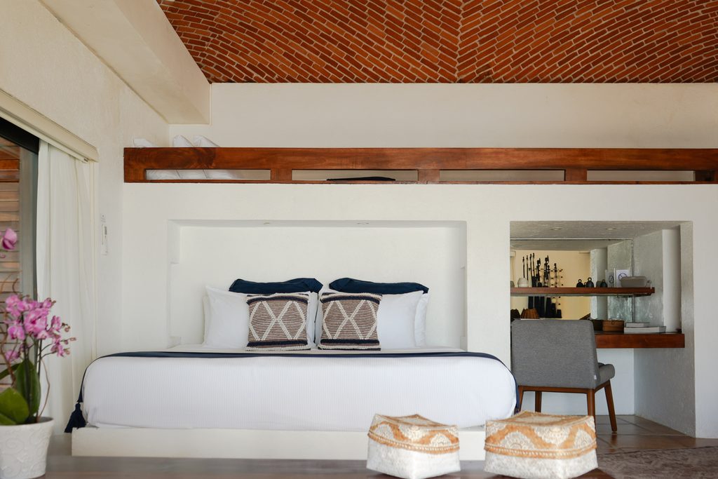 Recámara principal con techo artesanal de ladrillo y sala de estar en Casa Corazón