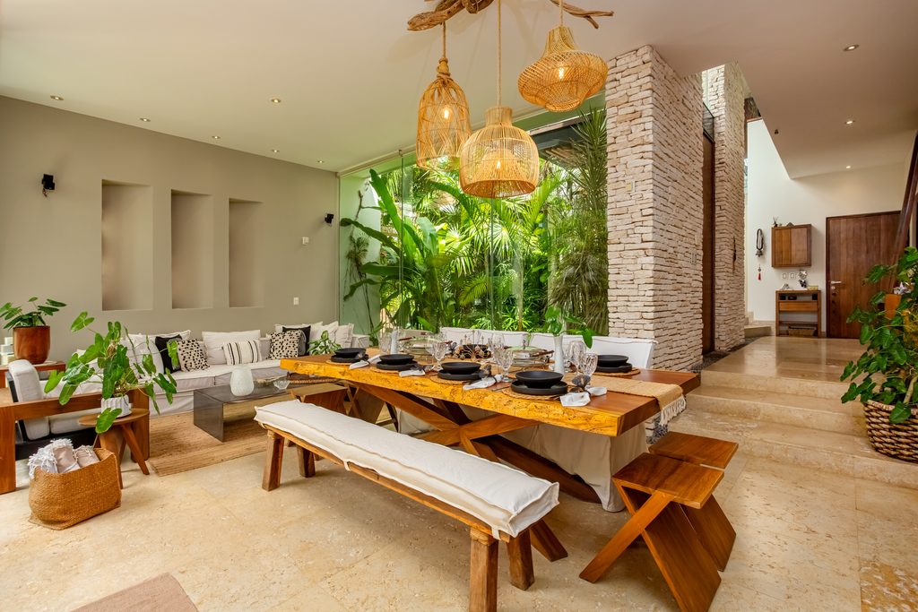 Comedor de mesa larga de madera con lámparas tejidas en Casa de las Estrellas, Playacar