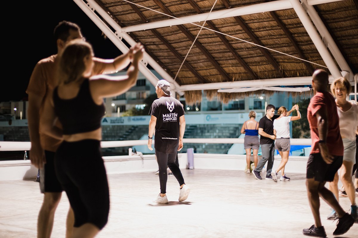 Instructor de salsa enseñando pasos básicos en la villa